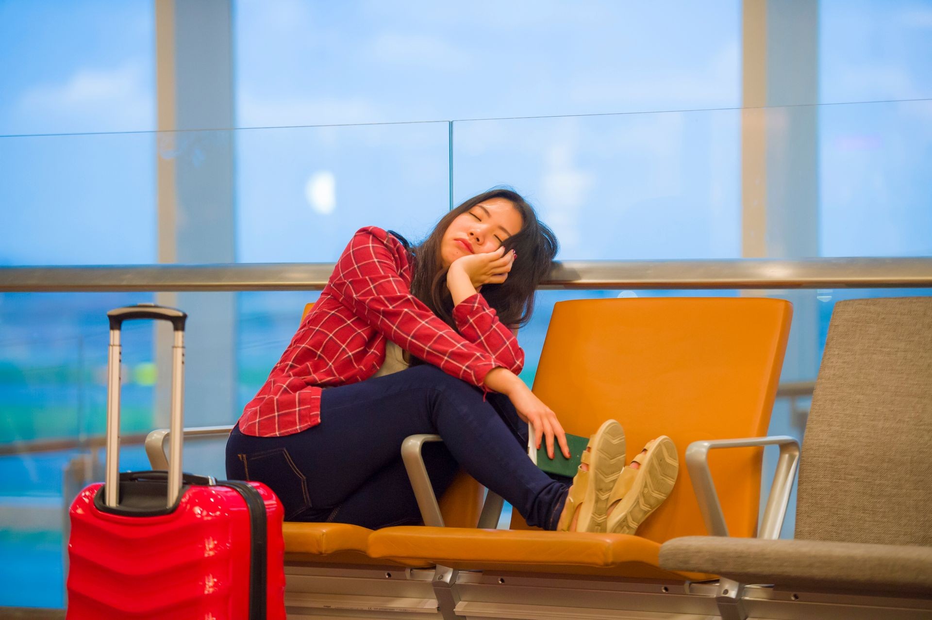 Chica durmiendo esperando el despegue de su vuelo retrasado